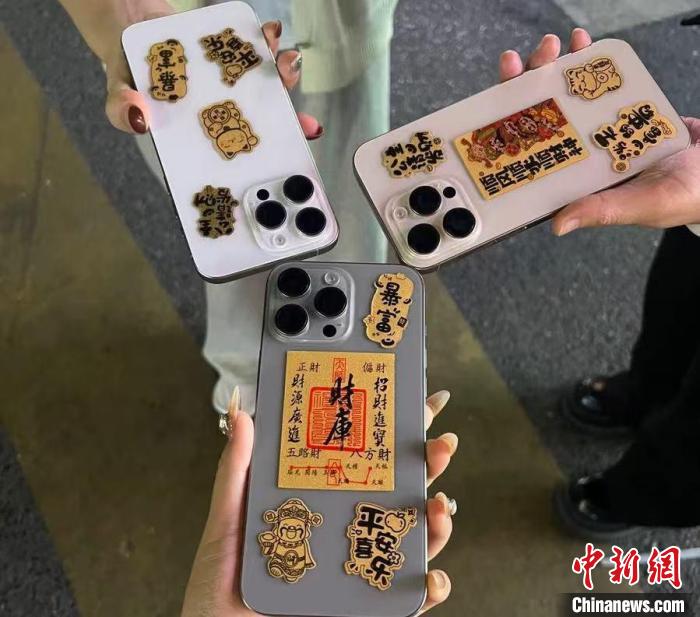 图为市民展示的黄金手机贴片。中新网记者 于晶 摄
