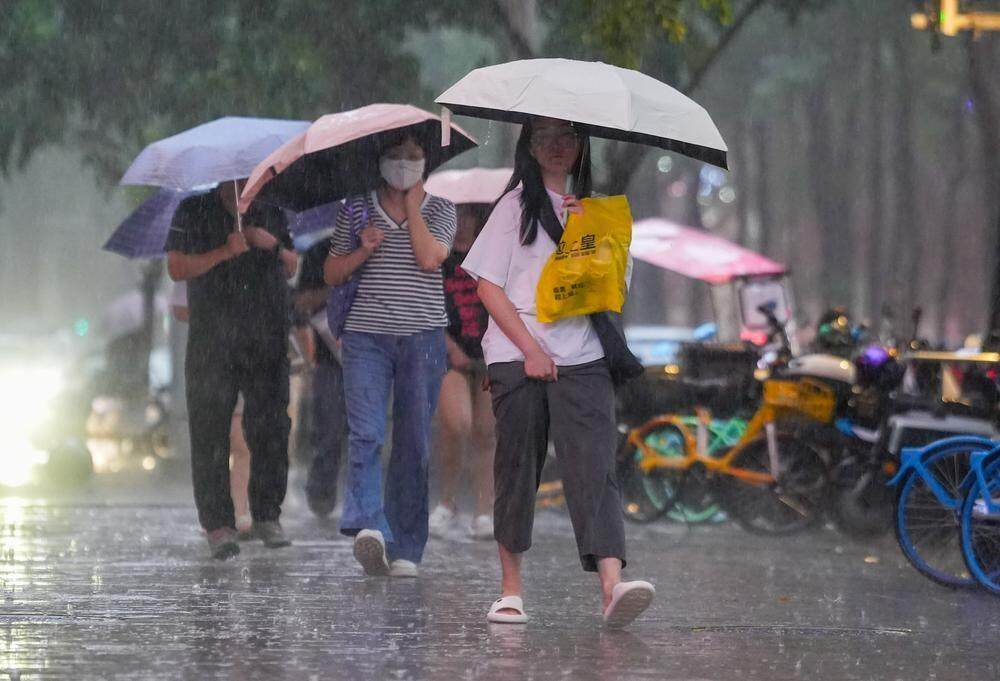 6月17日晚高峰，广州市民穿拖鞋冒雨出行。羊城晚报记者 梁怿韬 摄