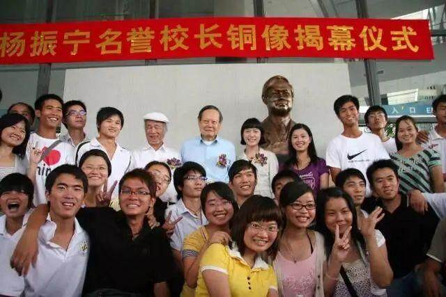  2009年5月，杨振宁与学生在铜像前合影。图片来源：东莞理工学院