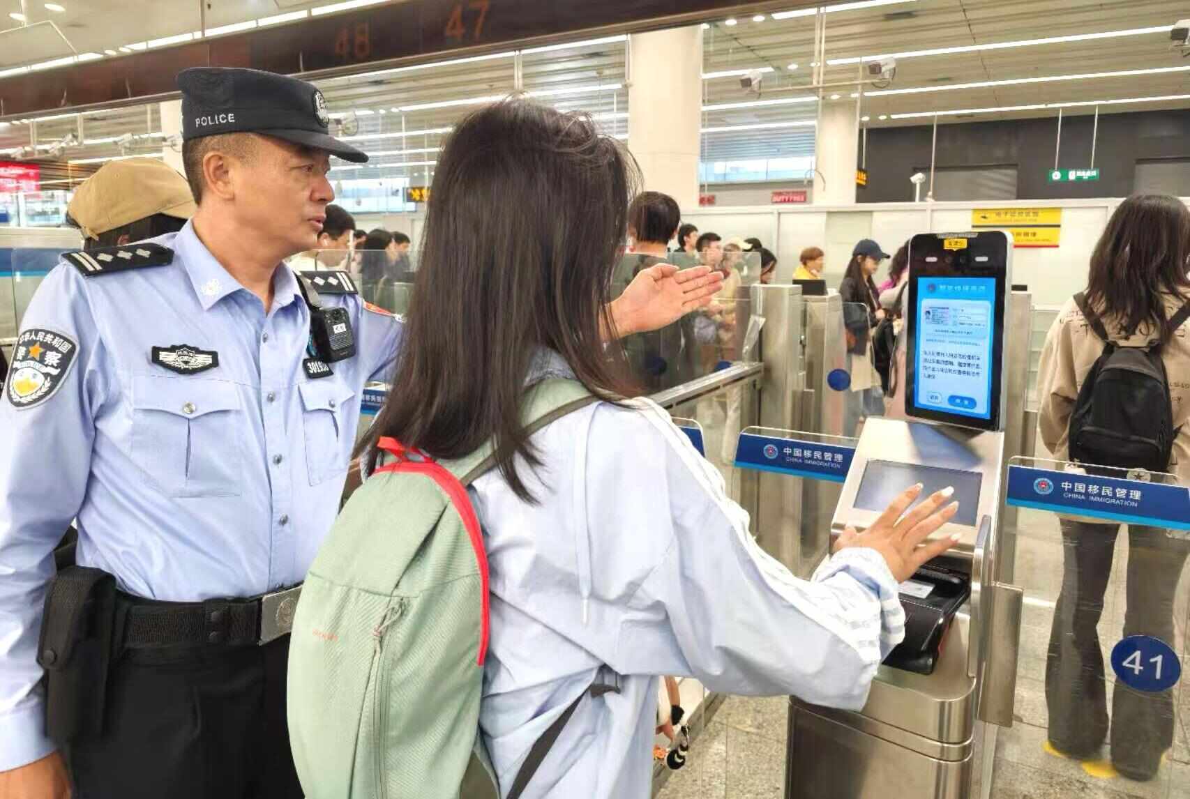 深圳福田口岸，旅客在边检民警的引导下刷脸通关。图/皇岗边检站