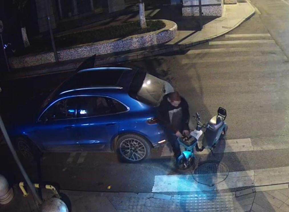 邱某将盗取的电瓶从共享单车车筐拿下,正准备放入车内。图片由雁江警方提供 邱某将盗取的电瓶从共享单车车筐拿下,正准备放入车内。图片由雁江警方提供