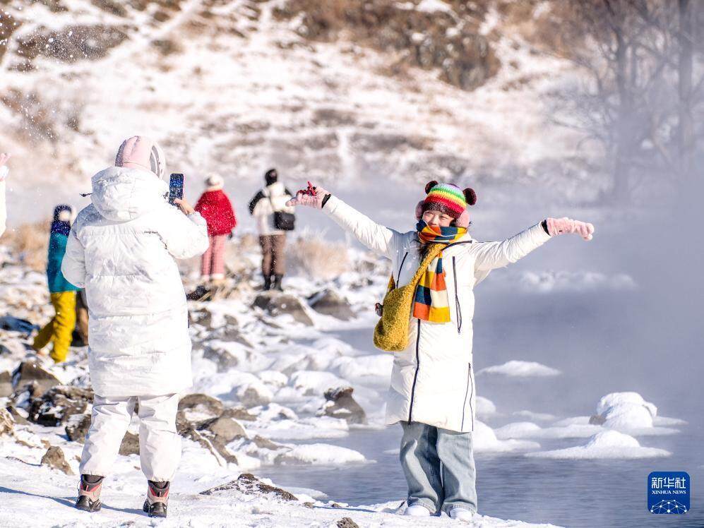 2026年1月1日，在内蒙古兴安盟阿尔山市，游客在哈拉哈河畔拍照留念。图/新华社