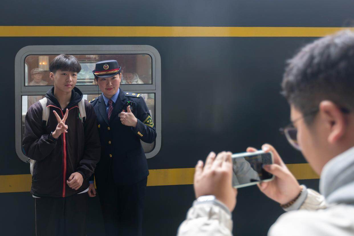  1月14日，火车迷在上海火车站与上海客运段沪港车队列车长李喆（左二）合影留念。新华社记者 王翔 摄