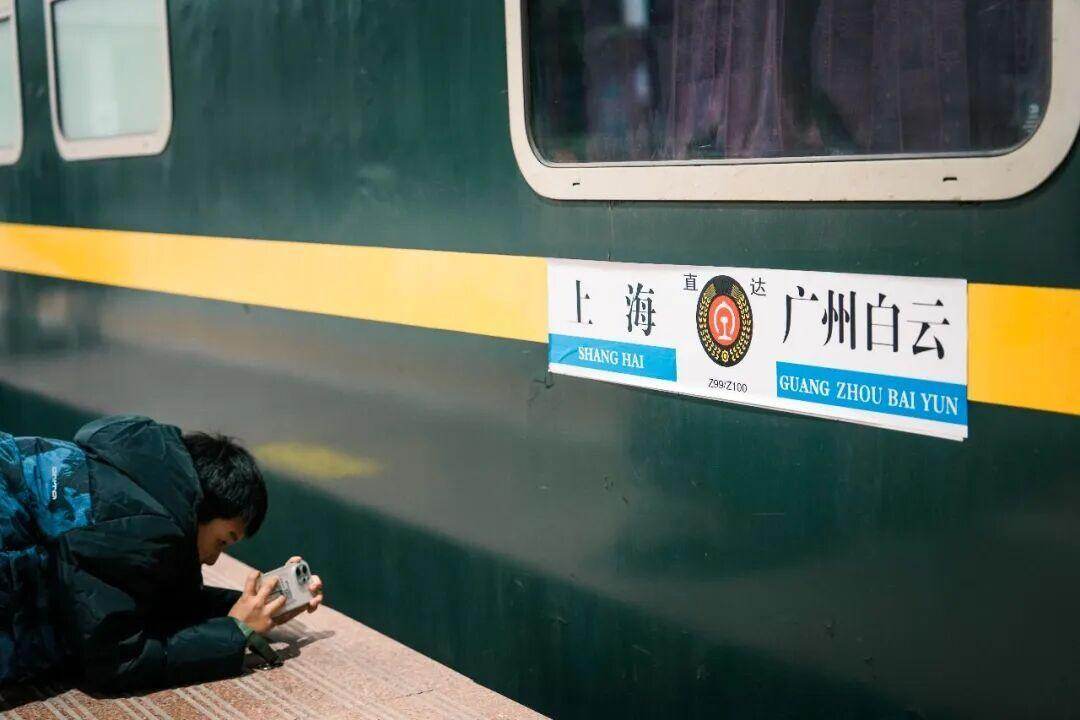  一位小铁路迷正在寻找满意的角度拍摄Z99水牌
