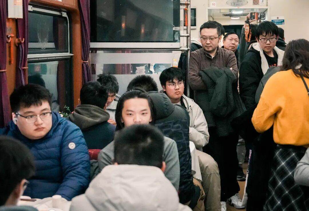  餐车座位十分紧俏，乘客在一旁排队等候