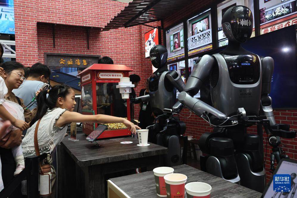 人形机器人在2025世界人工智能大会展览现场为参观者提供饮品。图/新华社