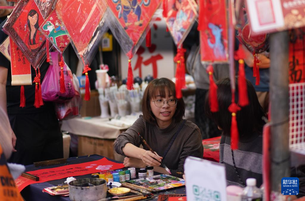 一位女士在台北年货大街上写春联（2月10日摄）。新华社记者 黄扬 摄