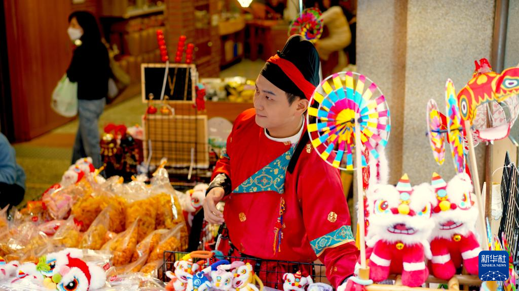 台湾青年吴旻义在台北年货大街上售卖年货商品（1月31日摄）。新华社记者 黄扬 摄