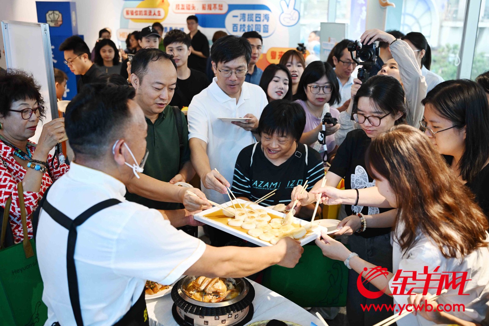 现场来宾在美食展示区品尝各色大湾区美食 现场来宾在美食展示区品尝各色大湾区美食