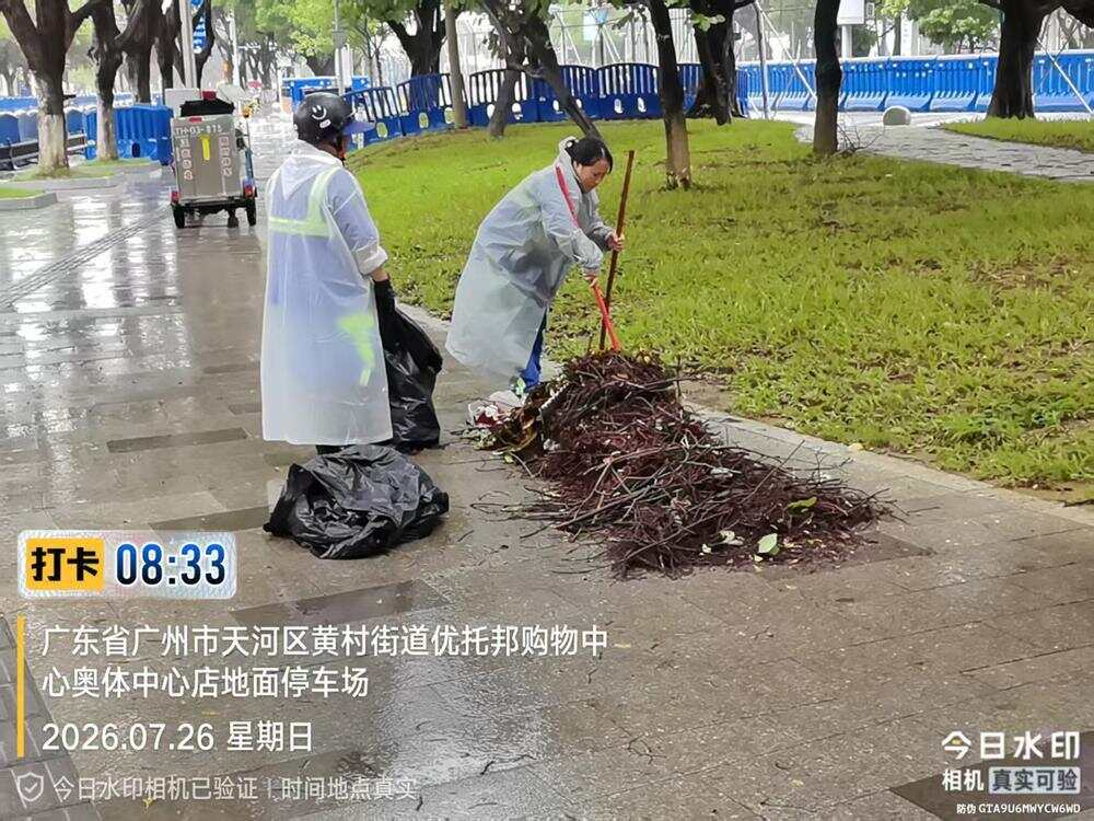 风雨减弱时，环卫工人立即开始对路面树枝和散落垃圾进行集中清理、归边收集