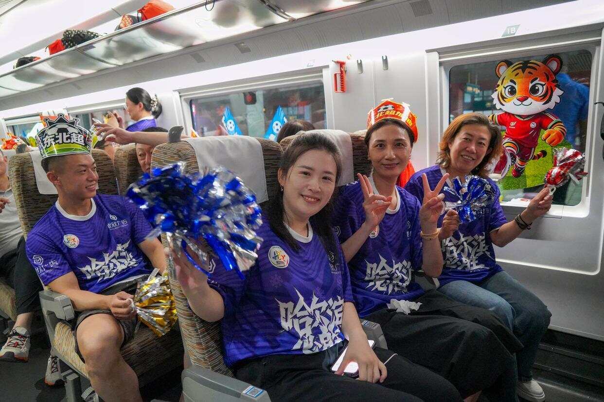旅客在“悠享龙江·球迷文化专题列车”G754次动车组列车车厢中合影