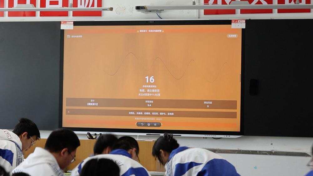 微信地震预警能力可接入学校现有的教学一体机、电子班牌和公共大屏,发生地震时,通过霸屏倒计时和高音量语音实现强提醒。图为校园场景预警演习画面 微信地震预警能力可接入学校现有的教学一体机、电子班牌和公共大屏,发生地震时,通过霸屏倒计时和高音量语音实现强提醒。图为校园场景预警演习画面